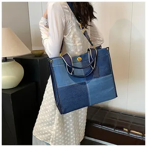 Détail du sac fourre-tout en denim bicolore avec fermoir doré et doubles lanières