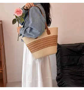 Detail of hand-woven straw tote bag with brown leather straps and textured knit patterns