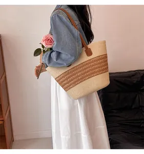 Detail of handwoven straw tote bag with brown leather straps for summer vacations