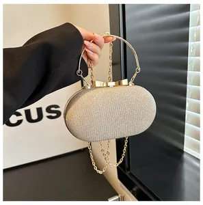 Detail of champagne gold evening bag with rhinestones, metal handle and bow clasp