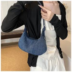 Lifestyle view of retro blue denim crescent underarm bag with adjustable silver buckle strap