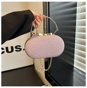 Macro shot of pink glitter evening bag with golden bow clasp and circular metal handle