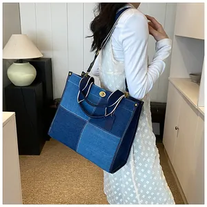 Détail du sac cabas en denim patchwork avec fermoir rotatif doré et bandoulière tissée
