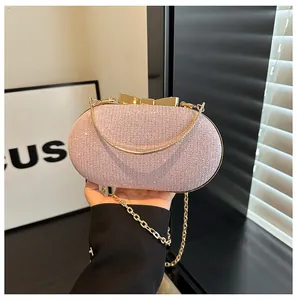 Detail of pink glitter evening bag with gold bow clasp and metallic chain strap