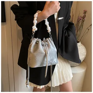 Detail of silver drawstring bucket bag with decorative marble-textured bead handle