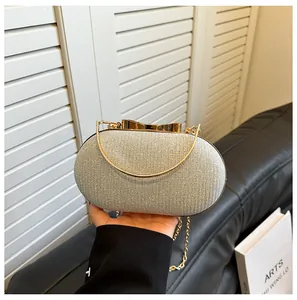 Detail of silver glitter evening bag with gold metal handle and bow clasp on chain