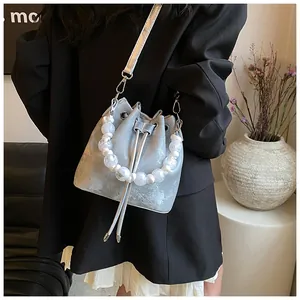 Fashion silver bucket bag with white bead handle shown with chic model outfit