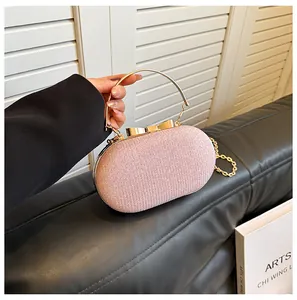 Close-up of pink sequin evening bag featuring golden metal bow clasp and ring handle