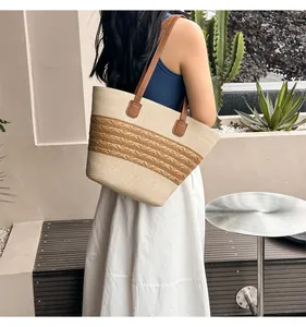 Detail view of woven tote bag with tricolor wave pattern and brown faux leather handles