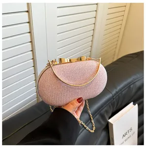 Detailed close-up of pink sequin evening bag with a gold metal bow clasp and chain strap