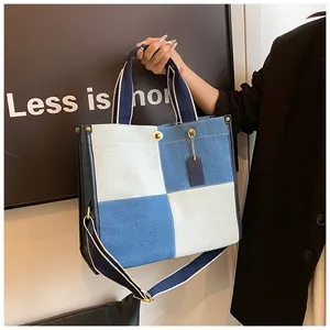 Détail du sac en jean montrant le tissu patchwork bleu et blanc et les rivets en métal