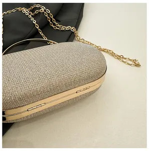Detailed macro view of the gold glitter clutch bag with metal frame and hinges