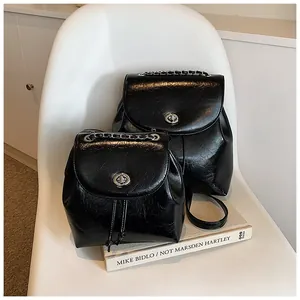 Detail von Mini-Rucksäcken in Schwarz aus glänzendem Lackleder mit silbernem Metallschloss