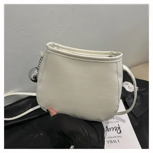 Détail du sac seau blanc en cuir plissé avec breloque boule argentée et bandoulière longue