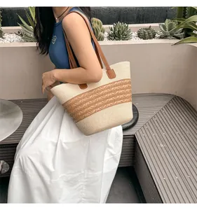 Detail of woven straw tote bag with brown leather straps and striped accents