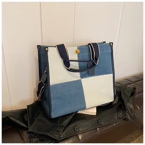 Détail du sac cabas en denim bleu avec patchwork de carrés et boucle métallique