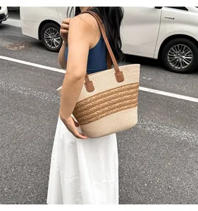 Detailed view of handmade woven straw tote with brown leather handles for summer travel