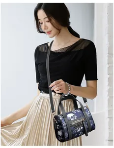 Detail of skull floral print crossbody bag with tassel zippers on a female model