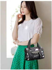 Gothic skull and floral print black Boston bag with metal rivets and shoulder strap
