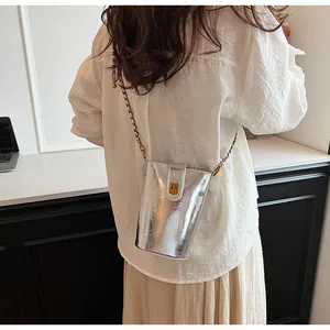 Détail du mini sac métallisé argenté avec bandoulière chaîne et fermoir doré rotatif