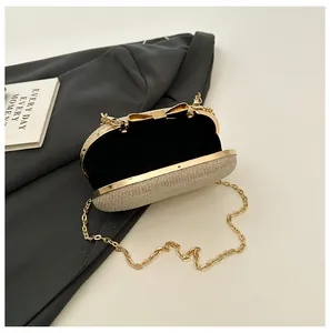Detail view of champagne sequin evening bag with gold bow clasp and chain strap