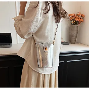 Détail du mini sac bandoulière argenté avec fermoir doré et bandoulière en chaîne
