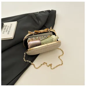 Detailed interior of champagne gold sequined evening bag with metal bow clasp and chain