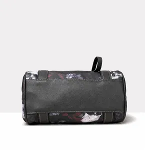 Detail view of the durable black PU leather base on a skull print cylindrical handbag