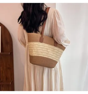 Detail of three-color woven straw tote bag with leather straps on a model back