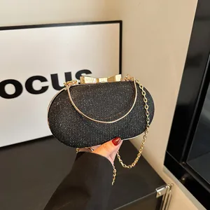 Sparkly black sequin evening bag with gold metal bow clasp and chain strap