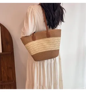 Detail of hand-woven straw tote with brown leather straps and striped texture