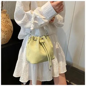 Detail of pistachio green drawstring bucket bag with elegant white pearl handle