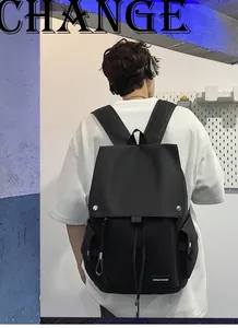 Detail view of water-resistant black nylon backpack with metal buckle and drawstring closure