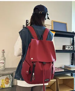 Macro detail of dark red canvas backpack with flap closure and magnetic metal buckles