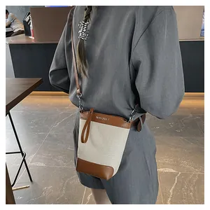 Détail du mini sac seau en toile avec finitions en cuir et logo MYCARE gravé