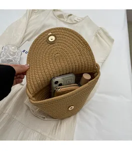 Detail view of the spacious inner compartment of this woven straw bag showing phone and wallet
