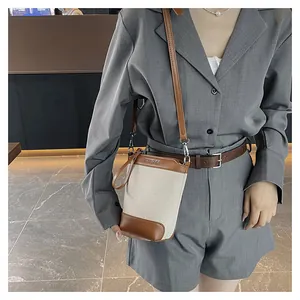 Détail d'un sac seau en toile avec finitions en cuir marron et logo VIVICARE élégant