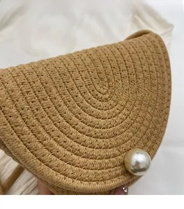 Detail of khaki woven bucket bag with concentric circular texture and large pearl buckle