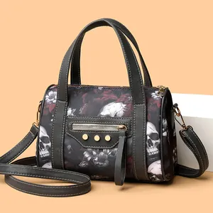 Detail of skull and floral print on crossbody bag with gold-tone hardware and studs