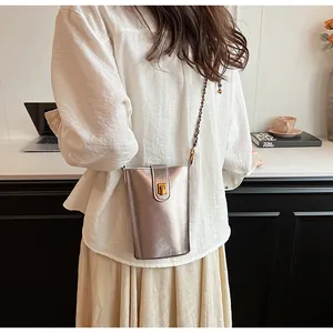 Détail du petit sac métallisé pour femme avec fermoir rotatif doré et bandoulière