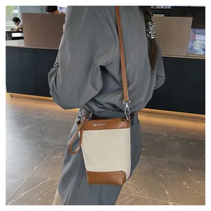 Détails du sac seau en toile avec finitions en cuir et accessoires en métal argenté