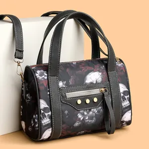 Detail view of gothic skull and red floral print on black fabric boston handbag