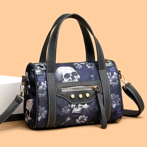 Detail of gothic skull and floral print on a Boston bag with gold rivets and zippers