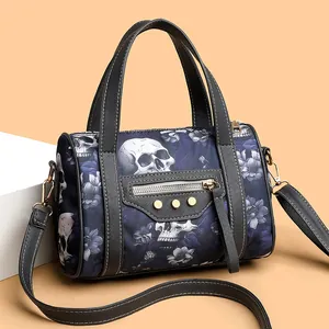 Detail of Boston bag with skull print, floral patterns, and golden rivets accents