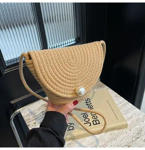 Detailed view of beige straw bucket bag featuring a large pearl button and woven texture