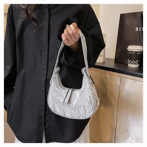 Detail van zilveren metallic hobo tas met kreukeltextuur en dubbele ritssluiting