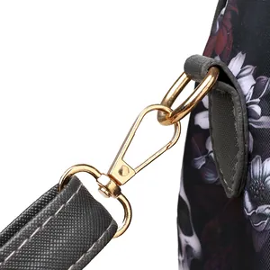 Close-up of golden metal lobster clasp and crossbody strap on skull print bag
