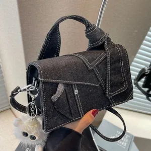 Denim crossbody bag in dark black with contrast stitching and plush bear charm