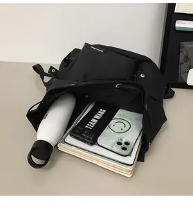 Detail view of black canvas backpack showing large capacity for laptop and daily items