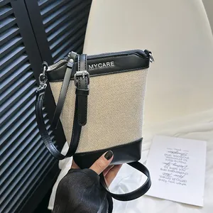 Sac seau minimaliste en toile crème et cuir noir avec logo MYCARE et bandoulière fine